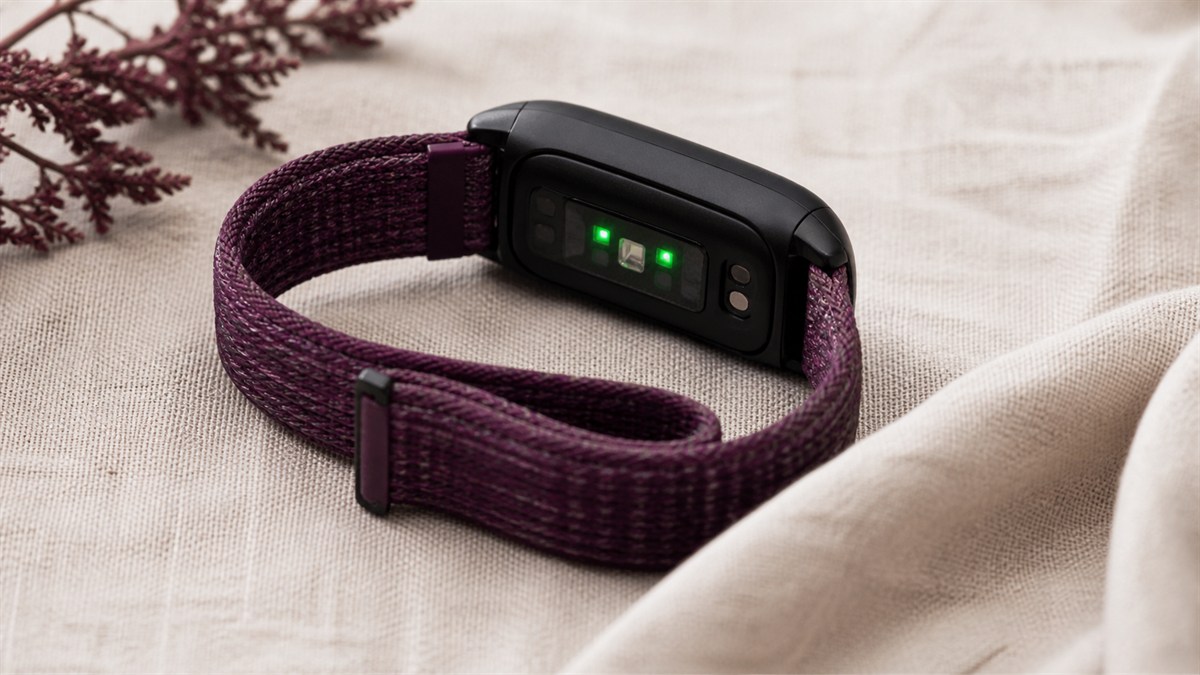 Green optical sensors on the underside of a fitness tracker.